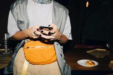 Midsection of businessman using smart phone in workplace