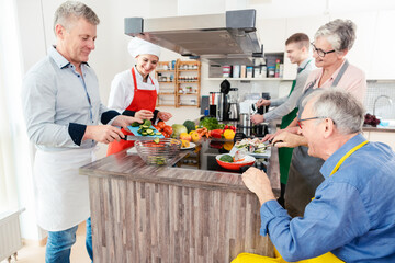 Chef showing trainees the secrets of healthy cooking in her kitchen