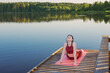 © Maya Kruchancova - girl doing yoga on wooden pier by lake in summer