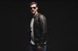© opolja - Fashion man, Handsome serious beauty male model portrait wear sunglasses and leather jacket, young guy over black background