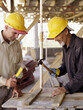 © Tetra Images - Hispanic workers using hammers at construction site