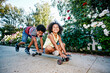 © Tetra Images - Mixed Race boy pushing sister on skateboard on sidewalk