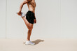 © VISTA by Westend61 - Barechested male athlete stretching in sunshine