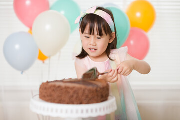 Wall Mural - toddler girl cut birthday cake for celebreating her 4th years birthday