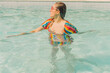 © VISTA by Westend61 - Dressed woman relaxing in swimming pool