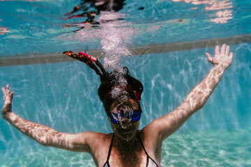 Wall Mural - young woman diving underwater in a pool. summer and fun lifestyle