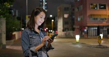 Wall Mural - Woman look at the smart phone at street in the evening