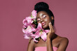 © Beauty Agent Studio - Art make up. Fashion beauty portrait of young African American model touching face with posing with lily flowers against pink background.