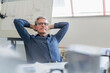 © Westend61 - Portrait of confident male entrepreneur relaxing while sitting with hands behind head at office desk