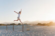 © Westend61 - Happy woman jumping in the air on the beach, Sardinia, Italy