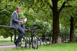 © Westend61 - Businessman reading newspaper while sitting on railing in public park