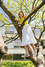 Portrait Of Happy Woman Standing In A Tree In A Park