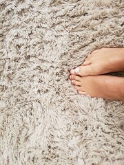 A lady's feet on the carpet.