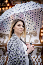 Young Woman Holding A Dotted Umbrella At A Carnival