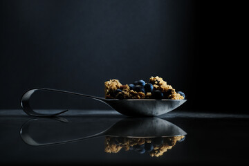 blueberry granola on dark moody background food photography 