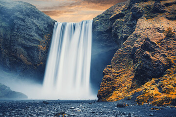 Wall Mural - Amazing Icelandic Landscape. Incredible view of famous Skogafoss waterfall during sunset. Dramatic Scenery of Iceland. Skogafoss Waterfall. Iceland the most beautiful and best travel place. postcard