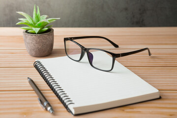 Wall Mural - Notebooks, pens, glasses, cactus  on wooden desks and loft walls with sunlight and copy space