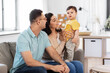 © Syda Productions - family and people concept - portrait of happy mother, father, little daughter and baby son sitting on sofa at home