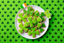Shamrock Cookies With Irish Flag, St. Patrick's Day Dessert. Green Textile Background. Top View.
