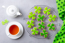 Shamrock Cookies On Cooling Rack With Cup Of Tea, St. Patrick's Day Dessert. Grey Background. Top View.