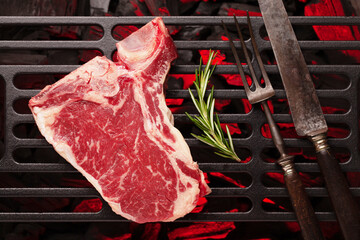 Canvas Print - Raw T-bone beef steak cooking on grill