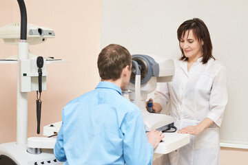 Wall Mural - ophthalmologist doctor in exam optician laboratory with male patient. Men eye care medical diagnostic. Eyelid treatment.