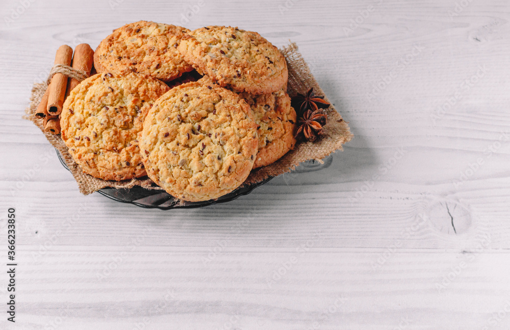 Fresh baked oatmeal cookie on plate with napkin decorated with cinnamon ...