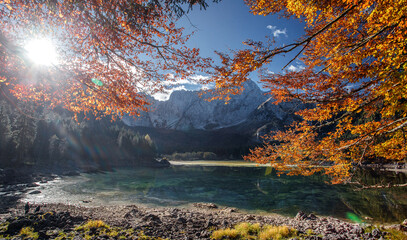 Fototapete - Impressive sunny autumn landscape of mountains. Beautiful natural scenery in Julian Alps. Scenic image of fairy-tale lake during sunset. Majestic Rocky Mountains on background. Fusine lake. Italy,