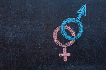 Man is equal to woman. The symbol of gender equality on the chalk Board