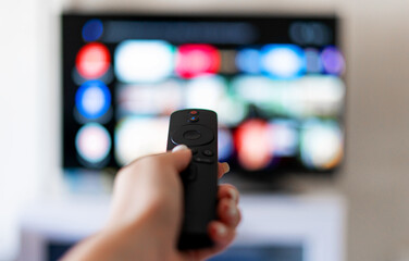 Hand holds remote control from smart TV