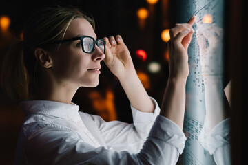 Wall Mural - digital monitor with public transport subway map. female standing at big display with advanced innov