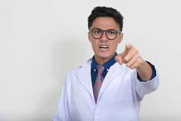 Wall Mural - Portrait of angry Asian man doctor with eyeglasses pointing at camera