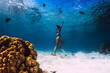 © artifirsov - Woman dive underwater with yellow fins in tropical ocean.