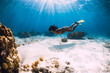 © artifirsov - Woman dive underwater with yellow fins in tropical ocean.