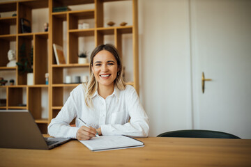 Wall Mural - Portrait of a smiling female entrepreneur at home office.