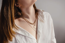 Close-up Young Woman In White Shirt Wearing Golden Necklaces. Imalist Lifestyle