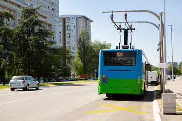 Wall Mural - Electric bus at a stop is charged by pantograph	