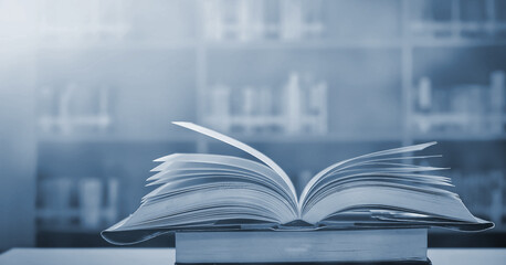 Wall Mural - ancient book opened on a wooden table with a sparkling golden background. With magical power, magic, lightning around a glowing book In the room of darkness