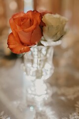 Sticker - Vertical closeup shot of short white and red roses in a small glass vase