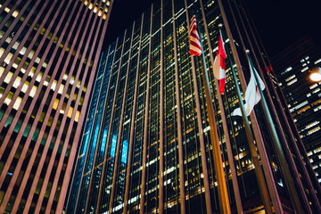 Evening view of skyscrapers shining with windows of corporate offices and apartments for rent in business district of city,tall building exterior with luxury real estate in megalopolis at night