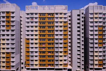 Modern urban architecture concept. Exteriors of typical public housing (HDB flats) in Singapore canberra estate on sunny day with blue sky. Wide angle panoramic shot; graphic.