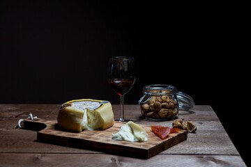 Sticker - Closeup shot of a glass of wine and cheese on wooden table