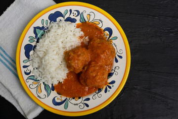 Wall Mural - Mexican meatballs with chipotle sauce and rice on dark background