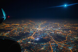 Aerial view to night city from the plane. Moon in the sky