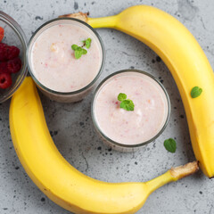 Wall Mural - Two glasses of summer smoothie with raspberries and banana