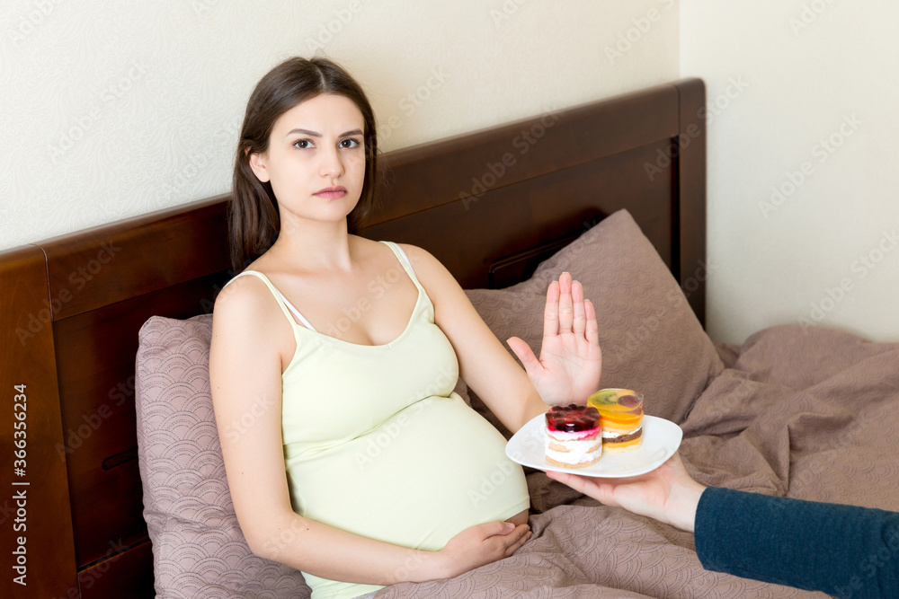 Pregnant Woman Lying In Bed Don T Want To Eat A Cake And Makes Stop Gesture No Sweet And Dessert During Pregnancy Concept Stock Gamesageddon