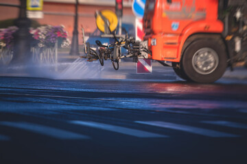 Wall Mural - Cleaning flusher sweeper machines washes the city streets road with water spray, group of municipal watering machines wash asphalt, process of street disinfection and cleaning from dust and dirt