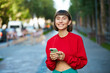 pretty girl in red holding phone on street