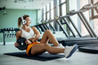 © Drazen - Young female athlete doing abdominal exercises with weight plate at health club.