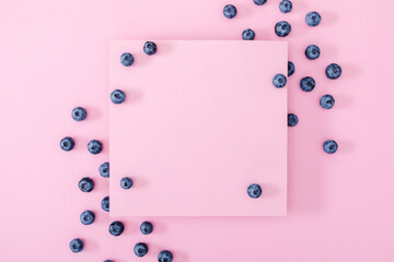 Fresh berries blueberry on pink background. Colorful fruit pattern of blueberries as background. Creative berries concept. Flat lay, top view, copy space